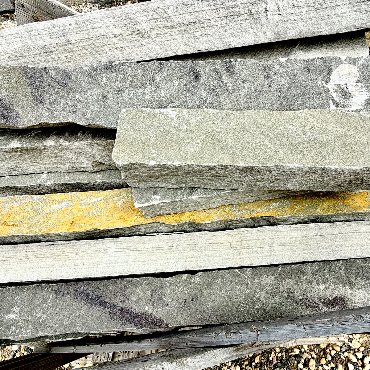 Close-up of Brandy Rubble Edging Stone showing its natural gray color, soft tan variations, and rugged surface.