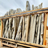 Stack of stone slabs with wooden frame against a cloudy sky
