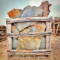 Stack of large stones in a wooden crate with a natural outdoor background
