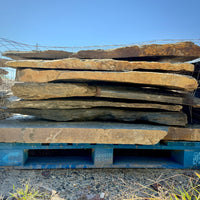 Moonlight Blue Large Laydown Flagstone displayed on a pallet, showcasing large, irregularly shaped natural granite pieces.