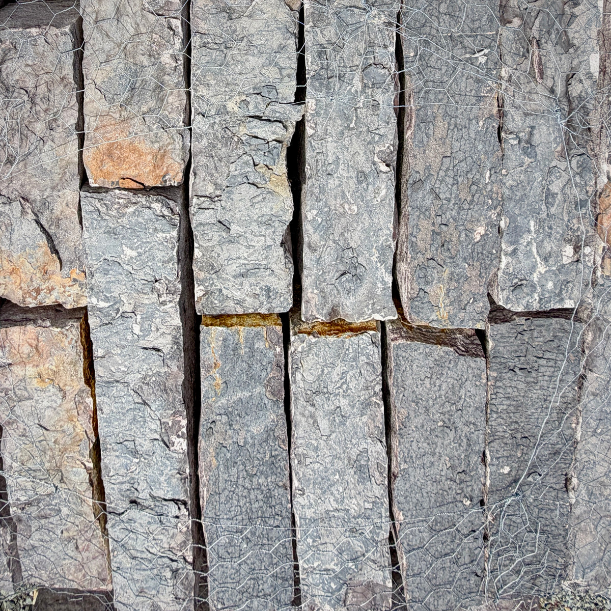 Close-up of Rock Island Lilac edging stone showing natural gray, blue, and lilac color variations.