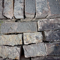 Close-up of Rock Island Lilac edging stone showing natural gray, blue, and lilac color variations.