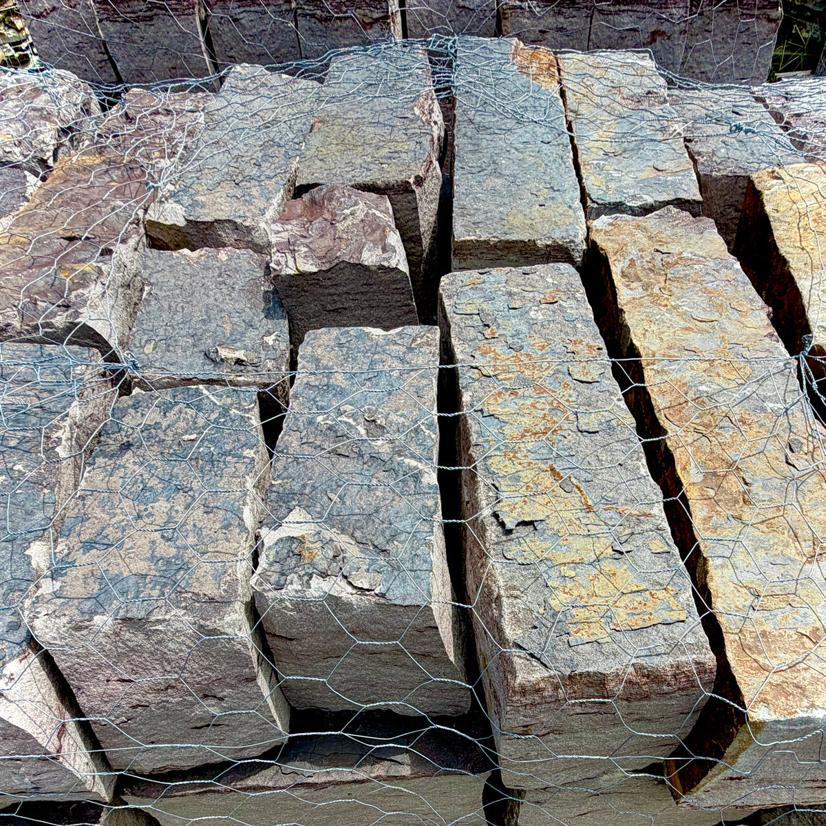 Close-up of Rock Island Lilac edging stone showing natural gray, blue, and lilac color variations.