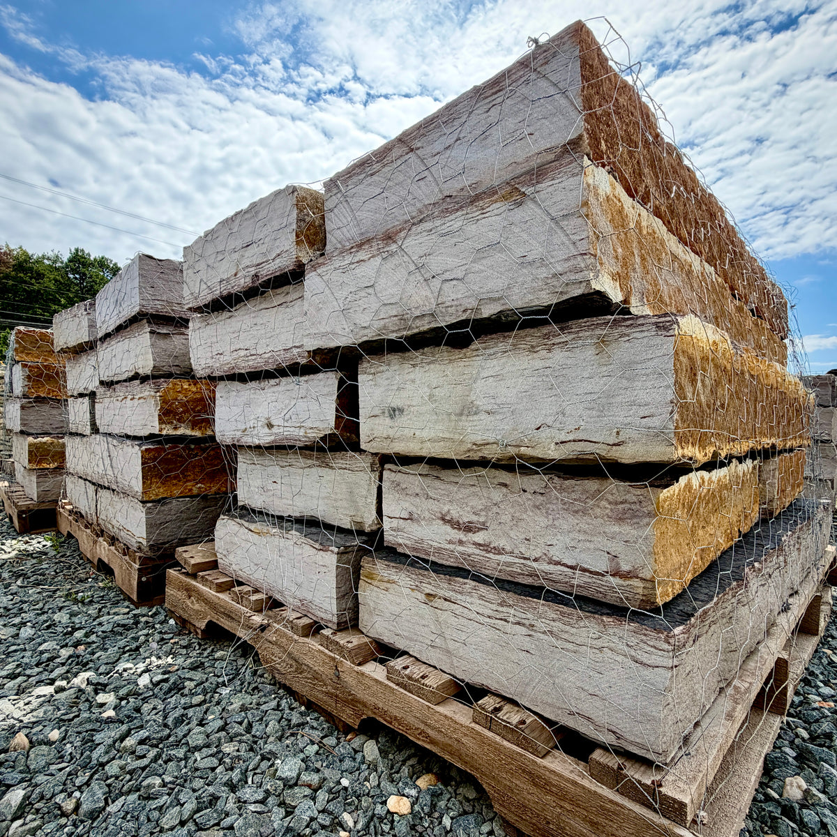 Side view of palletized Rock Island Lilac landscape steps with rust-gold faces, gray tops, and 5–6 inch thickness