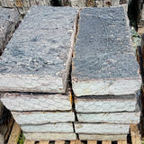 Rock Island Lilac stone steps on a 2,000 lb pallet, stacked face-out to show rust-gold cleft edges against a blue sky