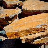 Large Summer Tan natural granite slabs with broad surfaces, irregular edges, and warm golden-brown color variation.