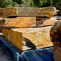 Side view of stacked Summer Tan granite landscape steps showing thick stone profiles and naturally textured edges.