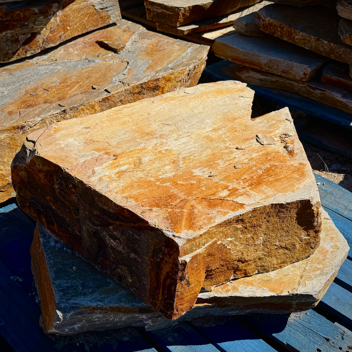 Large Summer Tan natural granite slabs with broad surfaces, irregular edges, and warm golden-brown color variation.