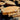 Summer Tan large granite landscape slabs stacked on pallets, showing natural tan and gold colors and rugged stone edges.