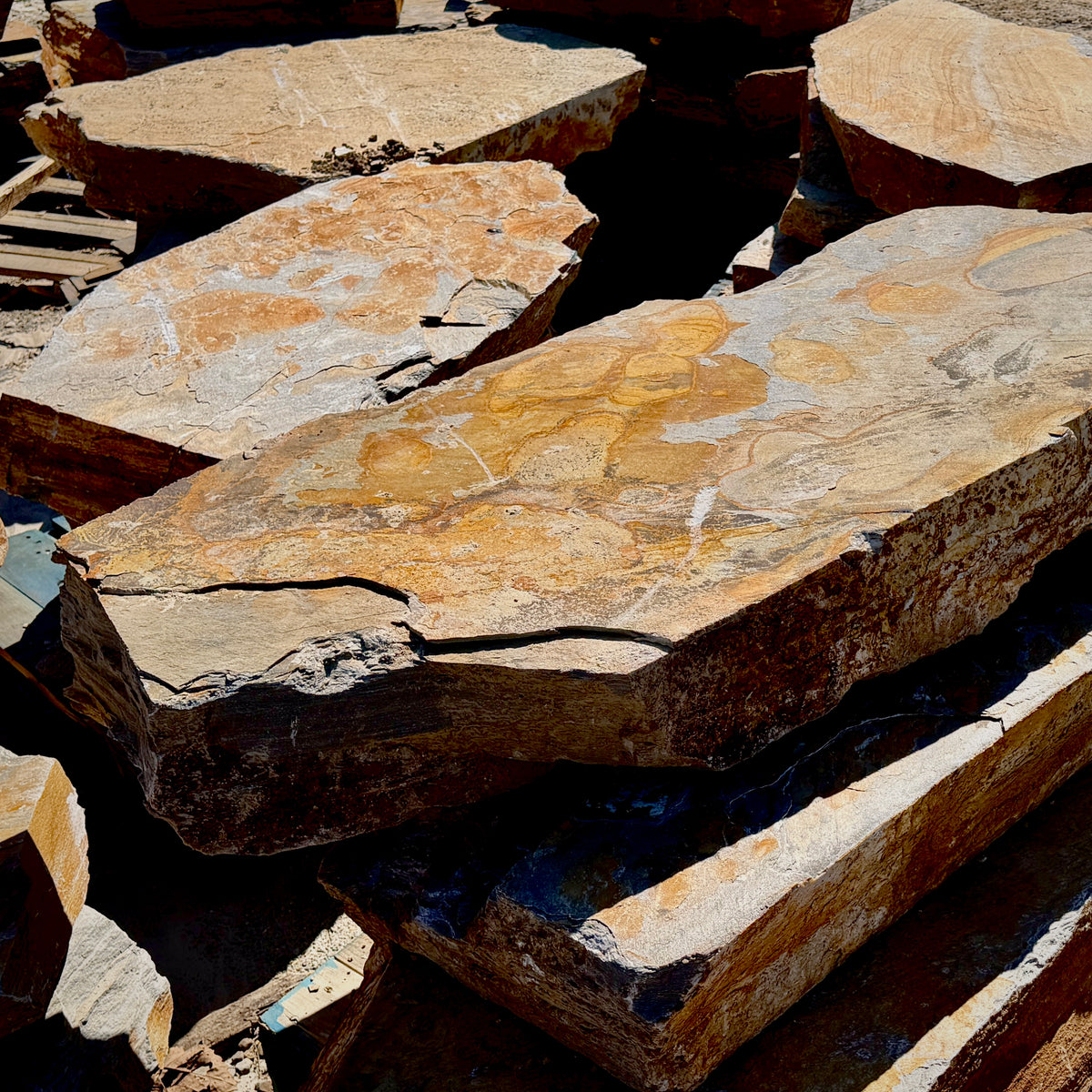 Thick Summer Tan granite landscape step slabs with natural chiseled edges and layered tan, brown, and gray stone.