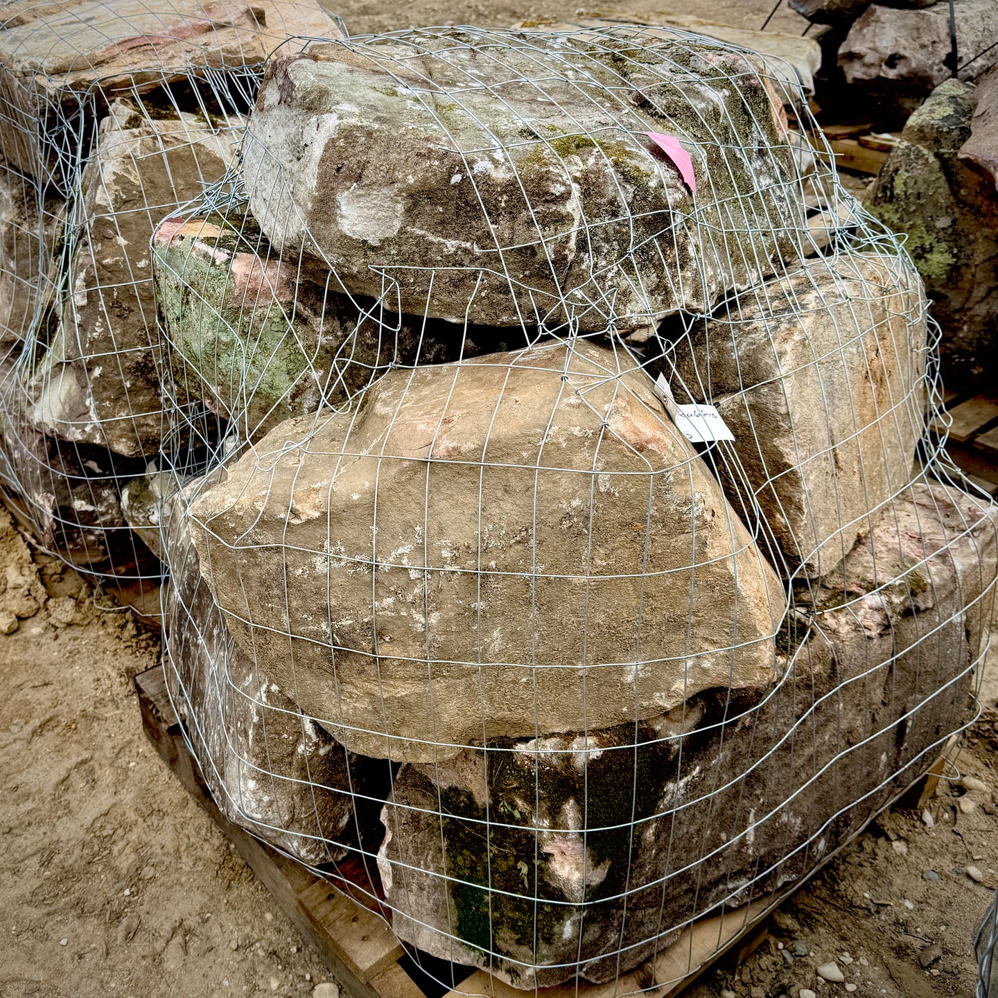 Large stones wrapped in wire mesh on a rocky surface
