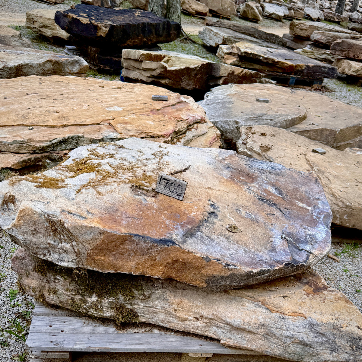 Oversized Tennessee fieldstone integrated with natural boulders in a custom pool grotto landscape.