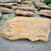 Oversized Tennessee fieldstone integrated with natural boulders in a custom pool grotto landscape.